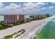 Expansive aerial view showcasing luxury condos along a pristine beach with clear ocean waters at 1310 Gulf Blvd # 6C, Clearwater Beach, FL 33767