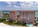Stunning aerial shot of twin beachfront towers with pools, lush landscaping, and ocean views at 1310 Gulf Blvd # 6C, Clearwater Beach, FL 33767