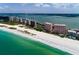 Wide aerial perspective of a coastal condo community with a beautiful beach and turquoise waters at 1310 Gulf Blvd # 6C, Clearwater Beach, FL 33767