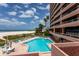 Beachfront pool and condo view offering a blend of relaxation and residential lifestyle with palm tree accents at 1310 Gulf Blvd # 6C, Clearwater Beach, FL 33767