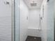 Modern walk-in shower with sleek fixtures, a built-in bench, and textured white tile at 1310 Gulf Blvd # 6C, Clearwater Beach, FL 33767