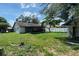 Spacious backyard featuring lush lawn, screened-in porch, white vinyl fencing, and large trees at 13603 Red Birch Pl, Tampa, FL 33625