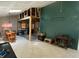 Unfinished living area featuring tile floor, dark accent wall, and kitchen area at 13603 Red Birch Pl, Tampa, FL 33625
