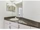 Bathroom vanity featuring a granite countertop, modern faucet and fixtures at 1624 Lullwater Ln, Lutz, FL 33549