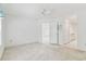 An airy bedroom features neutral carpeting, a ceiling fan and connecting bathroom/hallway at 1624 Lullwater Ln, Lutz, FL 33549