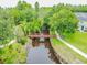 Scenic view of a wooden bridge over a tranquil waterway surrounded by lush greenery at 1624 Lullwater Ln, Lutz, FL 33549