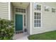Inviting front entrance with a green door, sidelight windows, and well-maintained landscaping at 1624 Lullwater Ln, Lutz, FL 33549