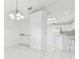 Bright kitchen and dining area with white cabinets, tile floor and modern chandelier at 1624 Lullwater Ln, Lutz, FL 33549