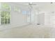 Spacious living room with tall windows offering plenty of natural light and neutral carpet flooring at 1624 Lullwater Ln, Lutz, FL 33549