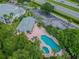 Aerial view of community pool and hot tub surrounded by lush landscaping and lounge chairs at 1624 Lullwater Ln, Lutz, FL 33549