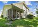 Screened porch with outdoor seating and lush greenery offers a tranquil space for relaxation and entertaining at 1624 Lullwater Ln, Lutz, FL 33549