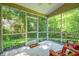 Relaxing screened porch featuring tile floors, string lights, and views of the lush backyard at 1624 Lullwater Ln, Lutz, FL 33549