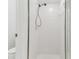 Updated white tiled shower with modern fixtures and glass door provides a clean aesthetic at 1624 Lullwater Ln, Lutz, FL 33549