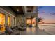 Elegant covered balcony showcasing a tranquil seating area and stunning views of the sunset over the water at 16365 Redington Dr, Redington Beach, FL 33708