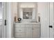 Contemporary bathroom features a gray vanity with marble countertop and a large rectangular mirror at 16365 Redington Dr, Redington Beach, FL 33708