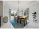 Bright dining room featuring an oval table, colorful rug, and large windows for natural light at 16365 Redington Dr, Redington Beach, FL 33708