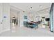 Bright dining room with modern lighting and access to a luxurious kitchen and living area at 16365 Redington Dr, Redington Beach, FL 33708