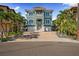Charming two-story home with a two-car garage, meticulously manicured lawn, and tropical palm trees at 16365 Redington Dr, Redington Beach, FL 33708