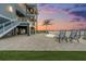 Stunning waterfront property with a luxurious pool area and multiple balconies showcasing beautiful sunset views at 16365 Redington Dr, Redington Beach, FL 33708