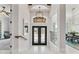 Bright foyer featuring glossy tile floors, an elegant chandelier, and a decorative front door at 16365 Redington Dr, Redington Beach, FL 33708