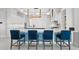 Well-lit kitchen featuring a breakfast bar with stylish blue barstools and modern lighting at 16365 Redington Dr, Redington Beach, FL 33708