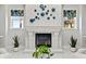 Bright living room featuring a fireplace, decorative art, and tropical patterned window coverings at 16365 Redington Dr, Redington Beach, FL 33708