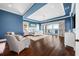 A luxurious main bedroom with blue walls and beautiful water views off the private balcony at 16365 Redington Dr, Redington Beach, FL 33708
