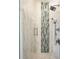 Shower with marble tile, shower head, and glass door at 16365 Redington Dr, Redington Beach, FL 33708