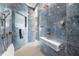 Luxurious walk-in shower with blue tile, multiple shower heads and bench seating at 16365 Redington Dr, Redington Beach, FL 33708