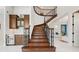 Elegant curved staircase with wood treads, iron railing, and custom bar with wine fridge nearby at 16365 Redington Dr, Redington Beach, FL 33708
