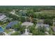 Aerial view of neighborhood, surrounding greenery, and nearby lake at 16367 Ashington Park Dr, Tampa, FL 33647