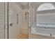 Beautiful tiled shower with a glass enclosure, and a soaking tub under a sunny window at 16367 Ashington Park Dr, Tampa, FL 33647