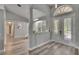 Inviting foyer with light wood-look floors, arched doorways, half wall and natural light streaming through the french doors at 16367 Ashington Park Dr, Tampa, FL 33647