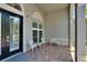 Cozy front porch seating area with decorative chairs and a table on brick pavers at 16367 Ashington Park Dr, Tampa, FL 33647