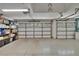 Spacious two car garage with storage shelves and light speckled flooring at 16367 Ashington Park Dr, Tampa, FL 33647