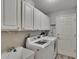 Laundry room with washer, dryer, utility sink, and ample cabinet space at 16367 Ashington Park Dr, Tampa, FL 33647