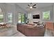 Living room with a leather sectional, television, and sliding glass door to a lanai at 16367 Ashington Park Dr, Tampa, FL 33647