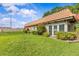 Charming home exterior with well-manicured lawn, lush bushes, and red tile roof at 1701 Pinehurst Rd # 9G, Dunedin, FL 34698