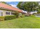 Beautiful home exterior with green lawn, mature tree, lush bushes, and red tile roof at 1701 Pinehurst Rd # 9G, Dunedin, FL 34698