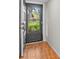Open front door, wood-look tile foyer and a view of the lush greenery outside at 1701 Pinehurst Rd # 9G, Dunedin, FL 34698