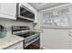 Efficient kitchen space showcasing stainless steel appliances, granite counters, and modern microwave at 1701 Pinehurst Rd # 9G, Dunedin, FL 34698