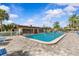 Community pool surrounded by lush landscaping, featuring an American flag and lounge chairs at 1701 Pinehurst Rd # 9G, Dunedin, FL 34698