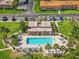 Aerial view of a beautiful community pool with lounge chairs and manicured landscaping at 1701 Pinehurst Rd # 9G, Dunedin, FL 34698