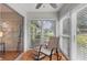 Relaxing sunroom with a rocking chair and ottoman, filled with natural light from large windows at 1701 Pinehurst Rd # 9G, Dunedin, FL 34698
