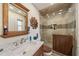 Bathroom featuring a tiled shower with glass doors, vanity with framed mirror, and tiled floors at 1707 Hibiscus S Cir, Oldsmar, FL 34677