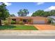 Charming single-story home with a manicured lawn, mature trees, and a two-car garage at 1707 Hibiscus S Cir, Oldsmar, FL 34677