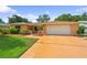 Charming single-story home with a lush green lawn and well-manicured landscaping in a desirable neighborhood at 1707 Hibiscus S Cir, Oldsmar, FL 34677