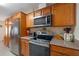 Well-lit kitchen featuring stainless steel appliances, ample counter space, and wood cabinets at 1707 Hibiscus S Cir, Oldsmar, FL 34677