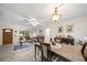 Inviting living room boasts tile flooring, a ceiling fan, and a light fixture above the dining table at 1707 Hibiscus S Cir, Oldsmar, FL 34677