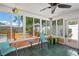 Relaxing sunroom with tile floors, ceiling fan, and large windows offering great views of the manicured backyard at 1707 Hibiscus S Cir, Oldsmar, FL 34677